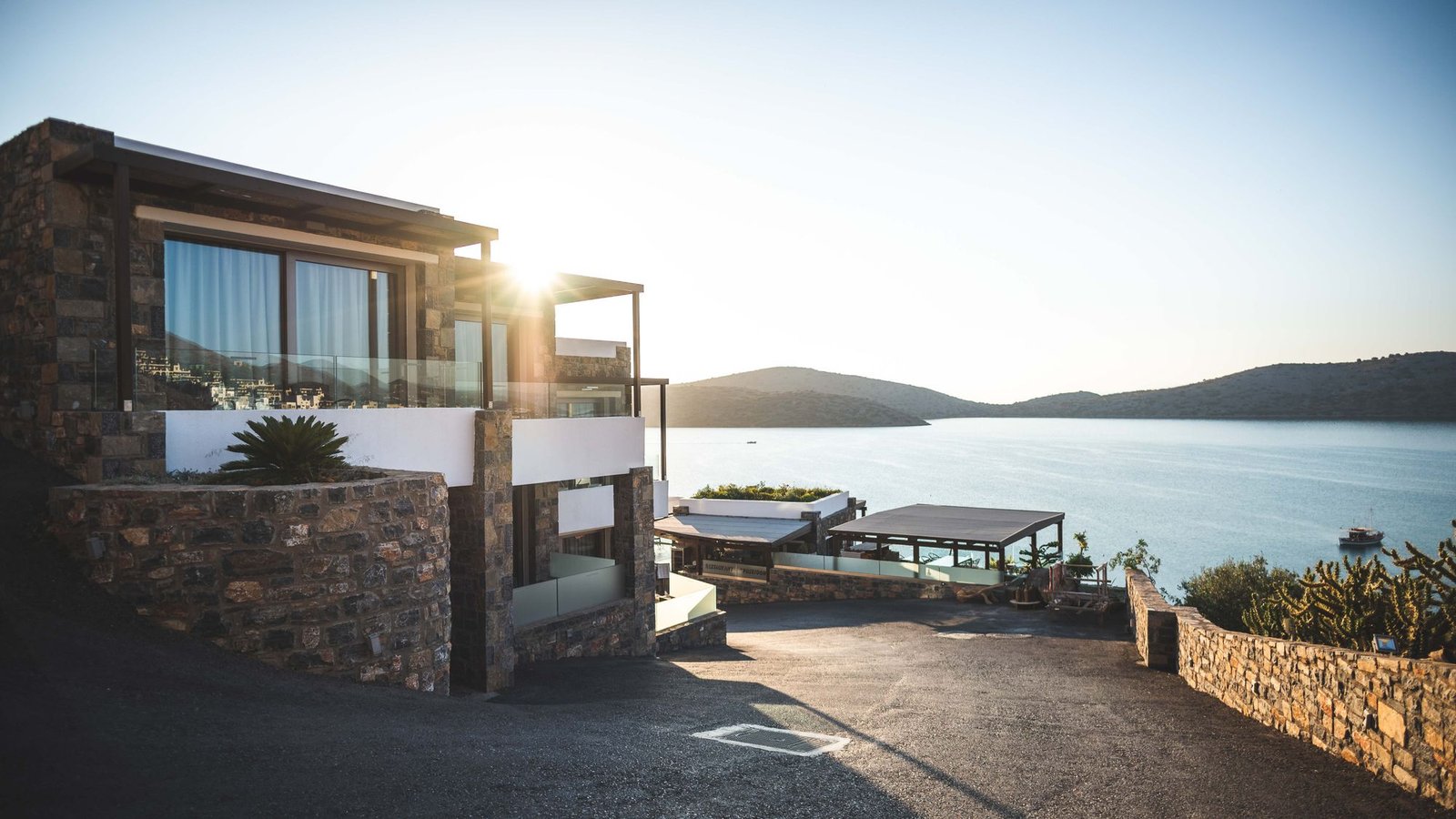 Modern hillside home overlooking water at golden hour